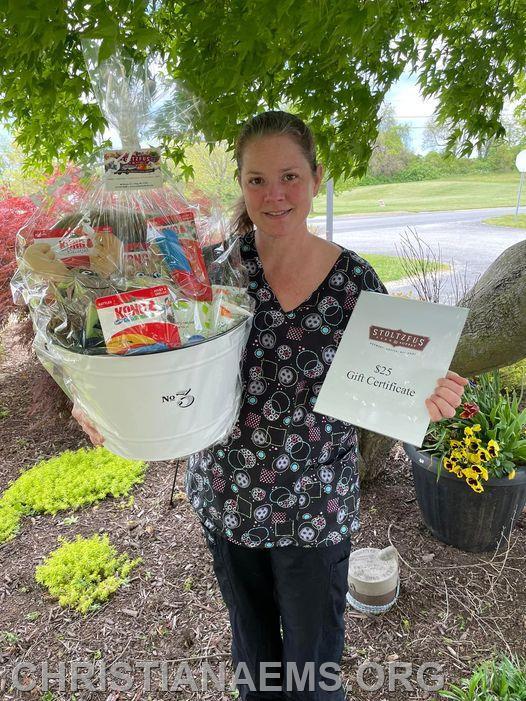 Pictured is Erika Lombardo with 2 raffles donated by Stoltzfus Feed & Supply, Inc- one is a basket full of pet supplies and one is a $25.00 gift certificate
